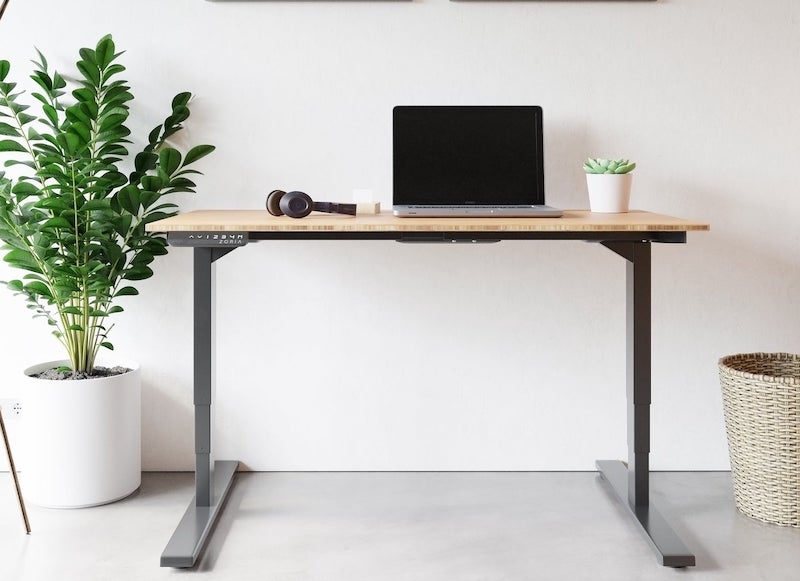 Eksklusivt hæve-sænkebord med bordplade i bambus og ben i sort metal