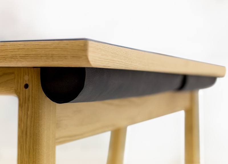 Skrivebord med sort bordplade og egetræsben